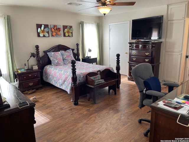 bedroom with dark hardwood / wood-style flooring and ceiling fan