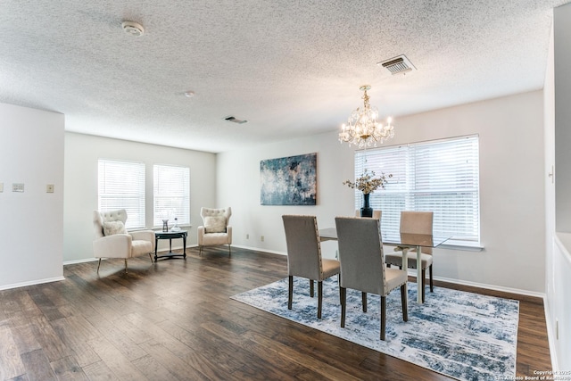 dining area featuring dark hardwood / wood-style floors, a chandelier, a textured ceiling, and a wealth of natural light