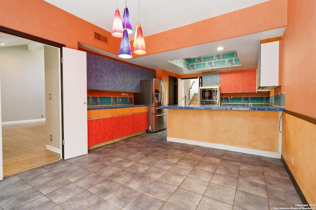 12519 Elm Manor St, San Antonio, TX 78230 - kitchen with stainless steel fridge with ice dispenser, built in microwave, baseboards, a peninsula, and pendant lighting