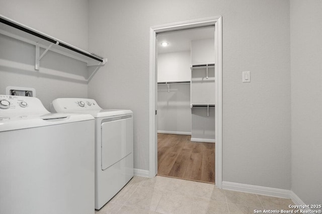 laundry room featuring washer and dryer and light tile patterned floors