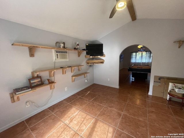 interior space with ceiling fan, a wall mounted AC, and dark tile patterned floors