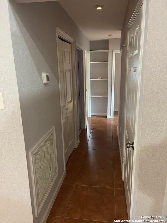 hall featuring dark tile patterned floors