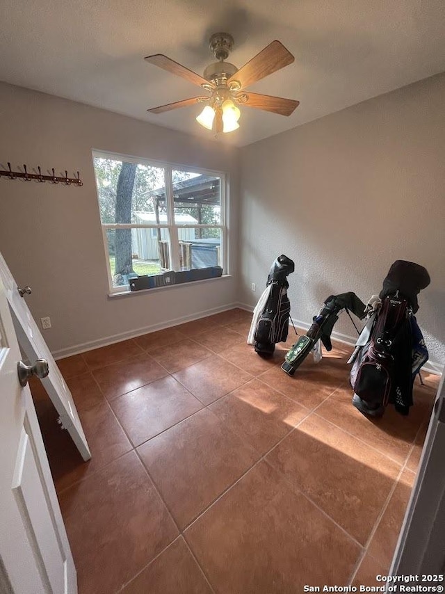 workout area featuring ceiling fan and tile patterned floors