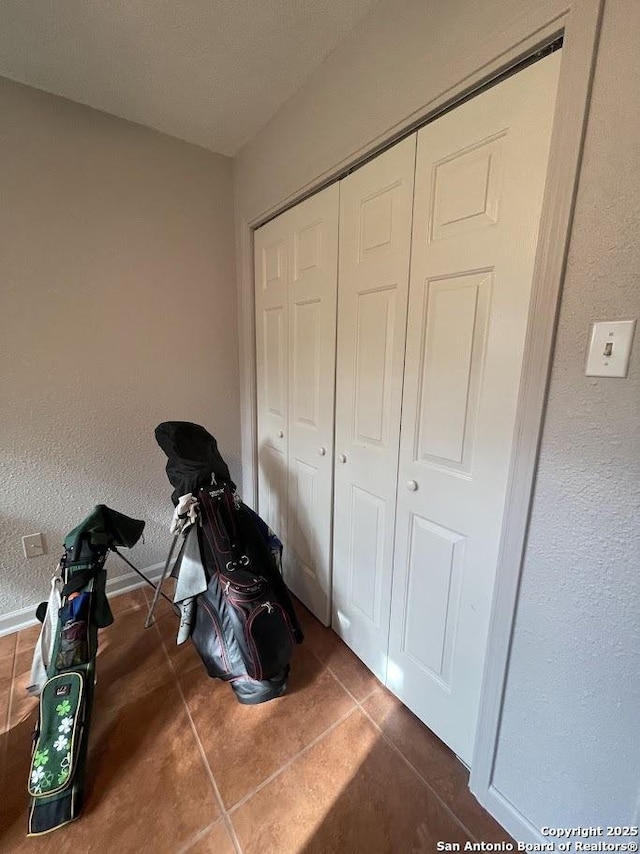 bedroom with a closet and dark tile patterned floors