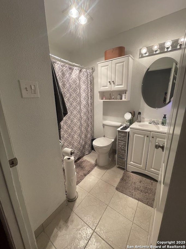 bathroom featuring vanity, toilet, and tile patterned flooring