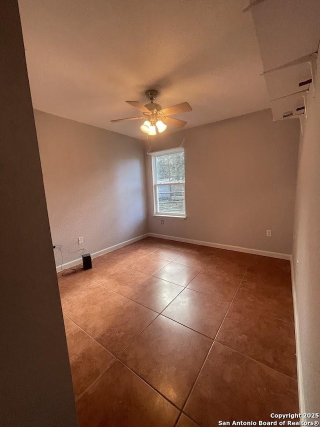 spare room with tile patterned floors and ceiling fan