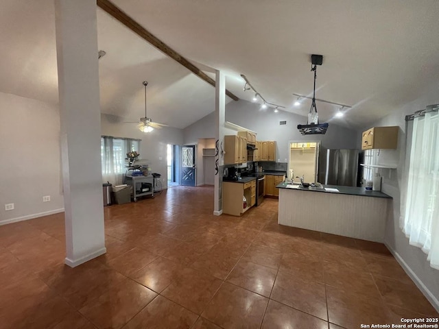 kitchen featuring high vaulted ceiling, dark tile patterned floors, ceiling fan, kitchen peninsula, and stainless steel appliances