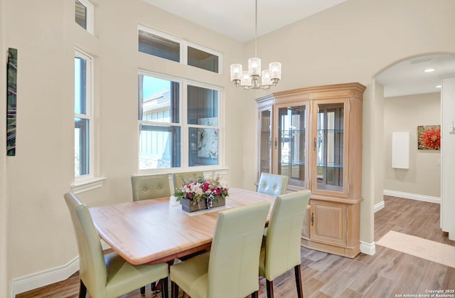 dining area with an inviting chandelier and light hardwood / wood-style flooring