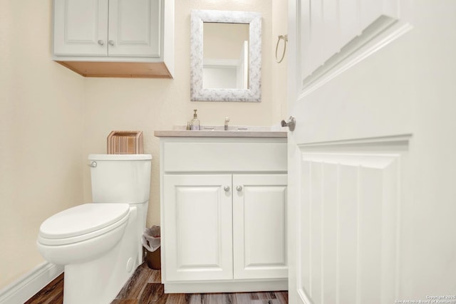 bathroom featuring vanity, toilet, and hardwood / wood-style floors