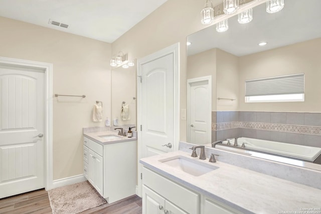 bathroom featuring vanity, a bathing tub, and wood-type flooring