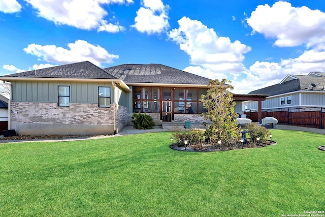 rear view of property with a sunroom and a yard