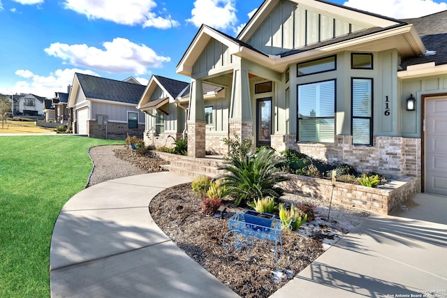 exterior space featuring a garage, covered porch, and a lawn