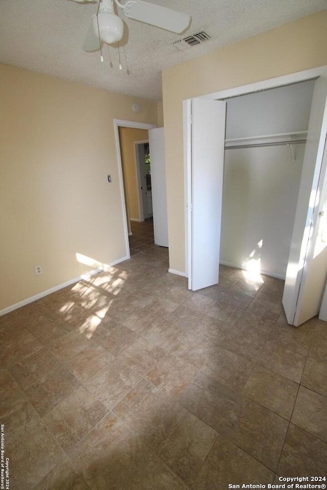 unfurnished bedroom featuring a textured ceiling, a closet, and ceiling fan