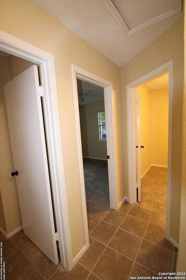 hall featuring tile patterned flooring and a textured ceiling