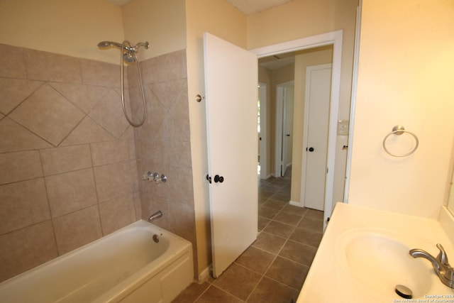 bathroom featuring tile patterned flooring, tiled shower / bath combo, and sink