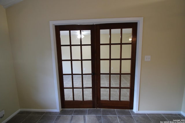 doorway to outside featuring dark tile patterned flooring and french doors