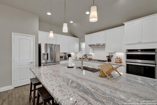 kitchen featuring sink, hanging light fixtures, white cabinets, and appliances with stainless steel finishes