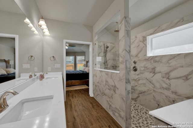 bathroom with a tile shower, vanity, and hardwood / wood-style flooring