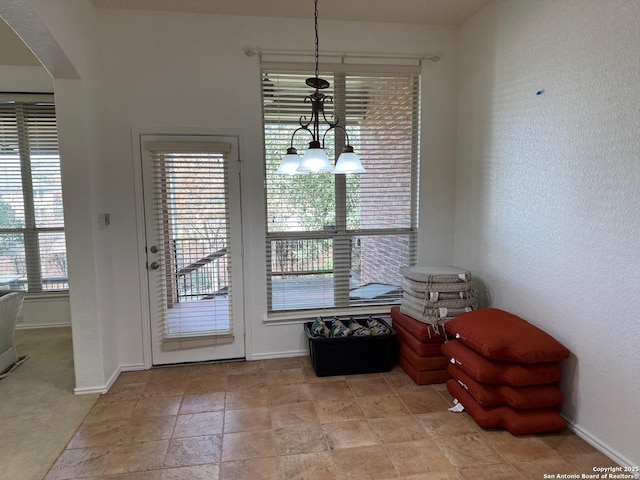 entryway with light carpet and a notable chandelier