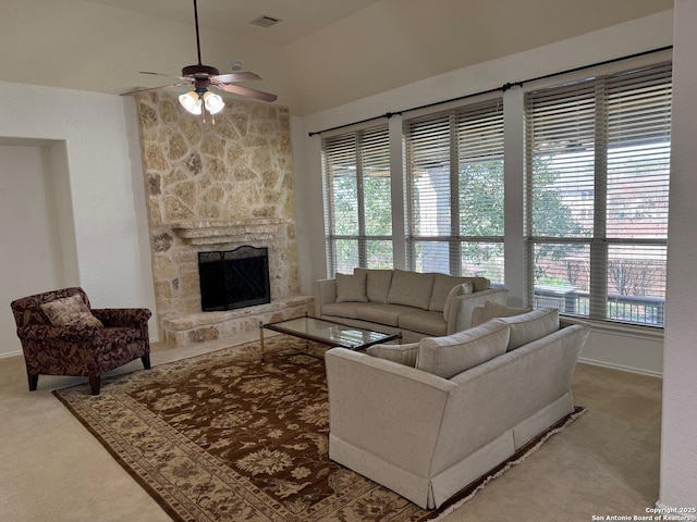 carpeted living room featuring vaulted ceiling, ceiling fan, and a fireplace