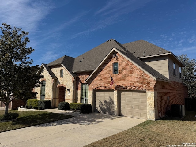 view of front facade featuring a garage, central AC, and a front lawn