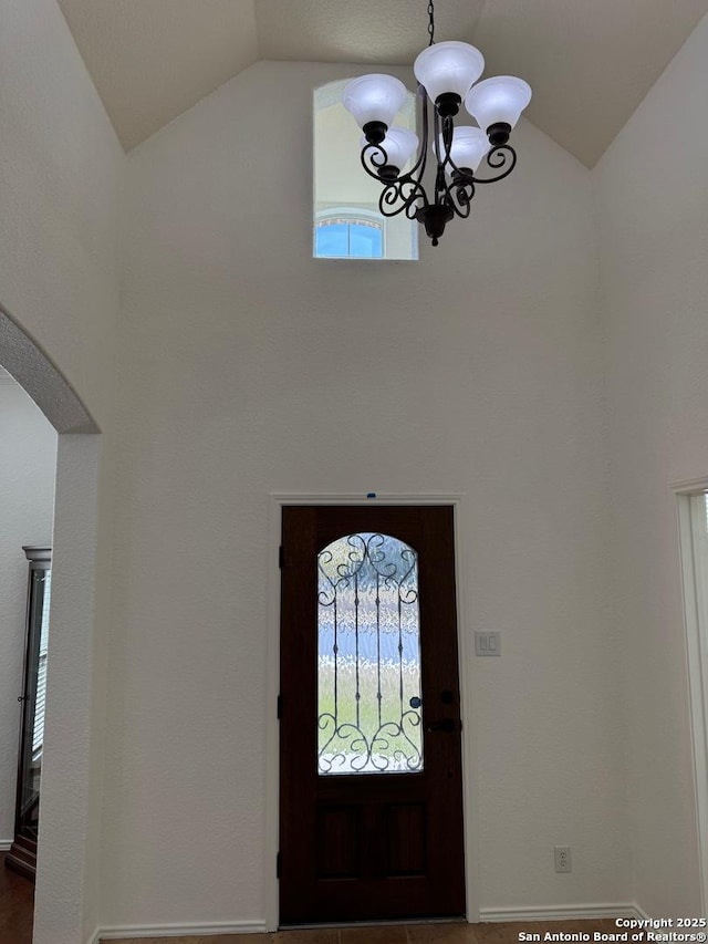 foyer with a notable chandelier and vaulted ceiling