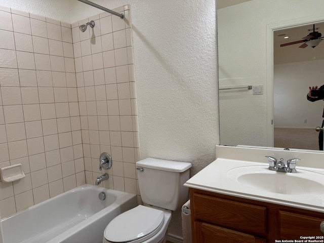 full bathroom featuring vanity, ceiling fan, toilet, and tiled shower / bath