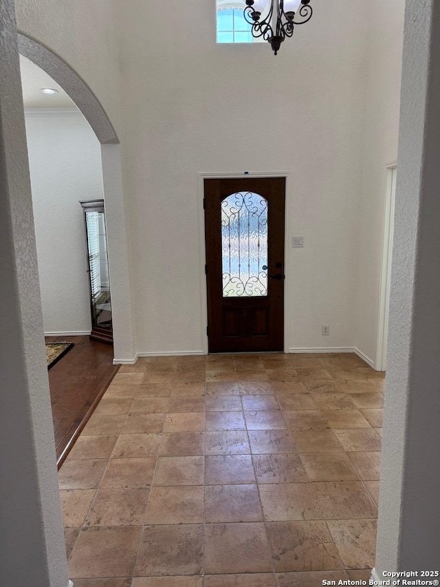 entrance foyer featuring ornamental molding and a chandelier