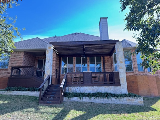 rear view of property featuring a lawn and covered porch