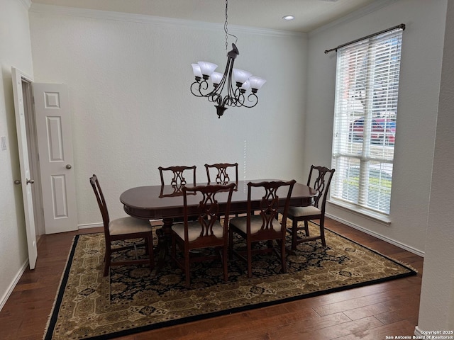 dining area with a notable chandelier, dark wood-type flooring, plenty of natural light, and ornamental molding