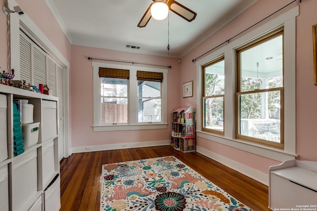 interior space with ceiling fan, ornamental molding, and dark hardwood / wood-style floors