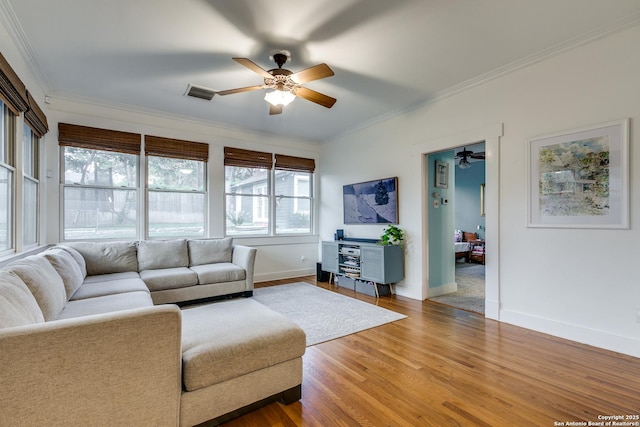 living room with hardwood / wood-style flooring, crown molding, and ceiling fan