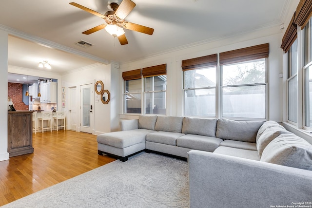 living room featuring crown molding, hardwood / wood-style floors, and ceiling fan