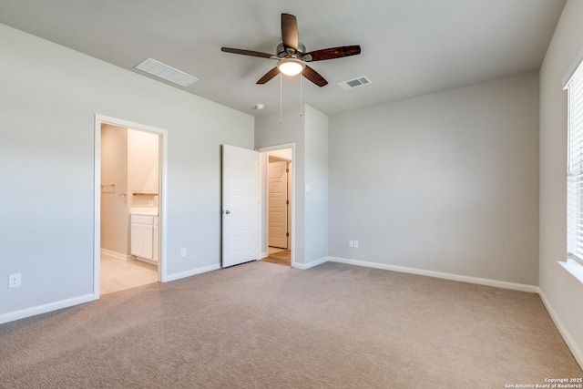 unfurnished bedroom with light colored carpet, ceiling fan, and ensuite bathroom