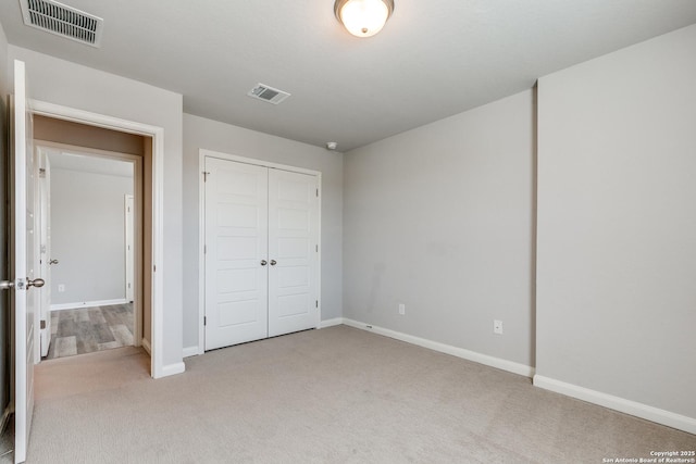 unfurnished bedroom featuring light carpet and a closet