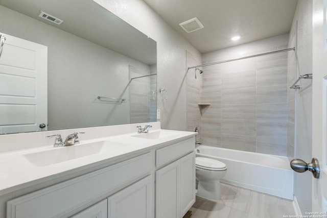 full bathroom featuring tiled shower / bath, vanity, and toilet