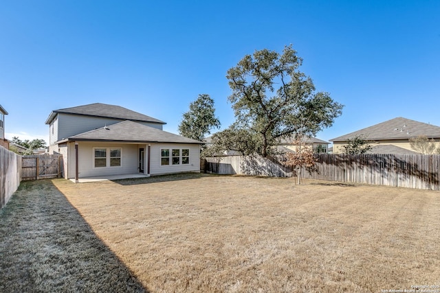 rear view of house with a patio and a lawn