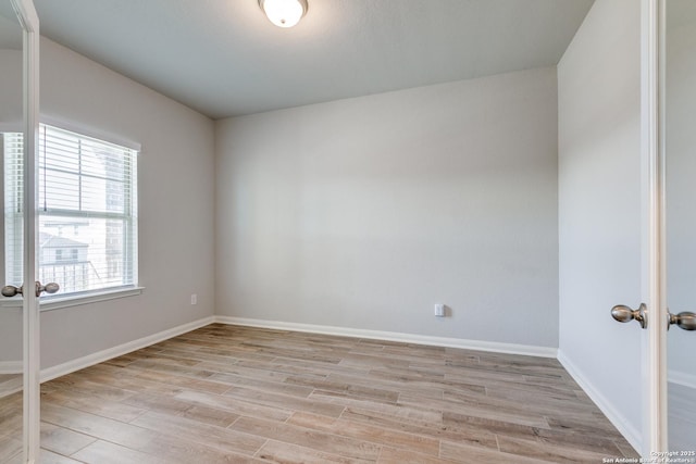 spare room with light hardwood / wood-style floors and french doors