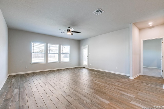 unfurnished room featuring a textured ceiling, ceiling fan, and light hardwood / wood-style flooring