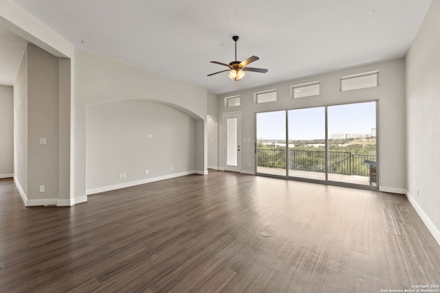 unfurnished living room featuring dark hardwood / wood-style flooring and ceiling fan