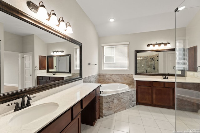 bathroom featuring tile patterned floors, vanity, separate shower and tub, and lofted ceiling