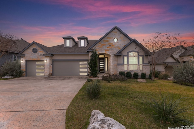 french country home featuring a garage and a yard