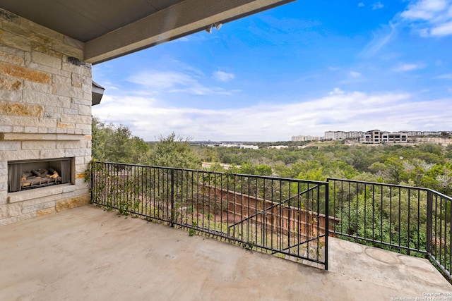 balcony featuring an outdoor stone fireplace