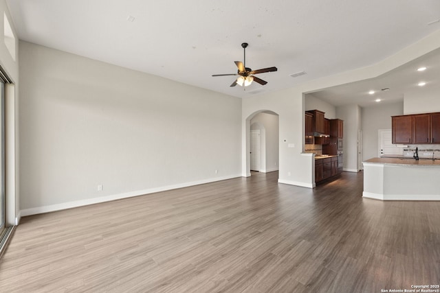 unfurnished living room with light hardwood / wood-style flooring and ceiling fan