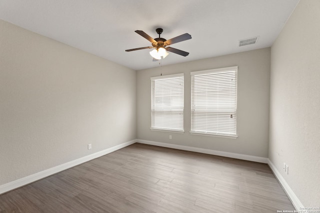 empty room with ceiling fan and light wood-type flooring