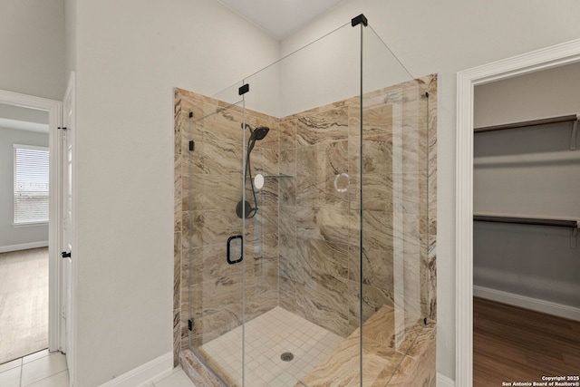 bathroom featuring a shower with door