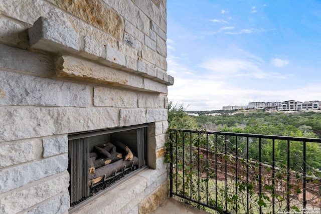 balcony with an outdoor stone fireplace