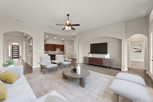 living room with dark hardwood / wood-style floors and ceiling fan