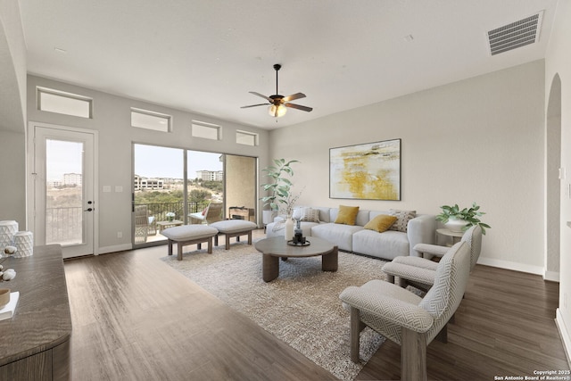 living room with ceiling fan and dark hardwood / wood-style flooring