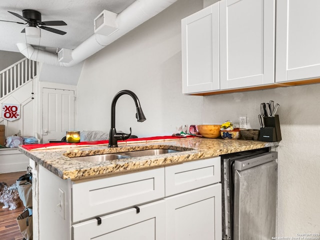 kitchen featuring sink, dishwasher, ceiling fan, light stone counters, and white cabinets